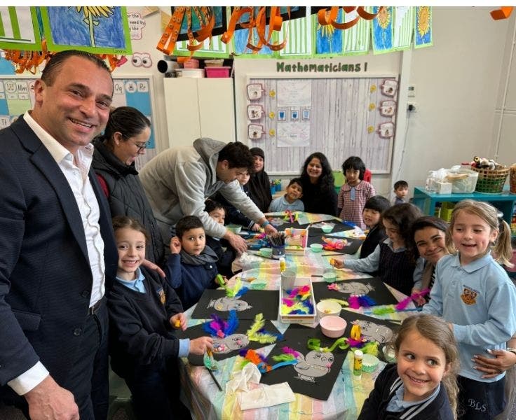 BLSPS Students sitting around a desk doing craft activities with some parents