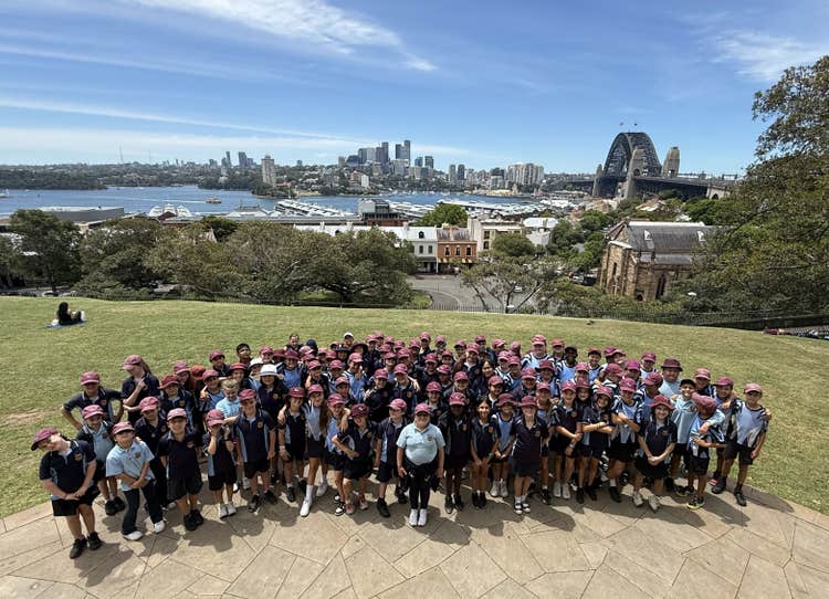students standing on the grass with Sydney harbour in the background