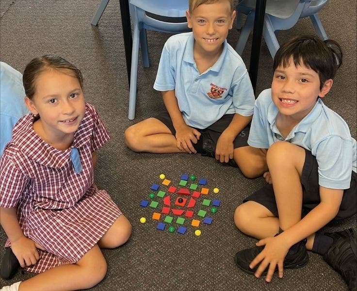 Three children playing a tile game