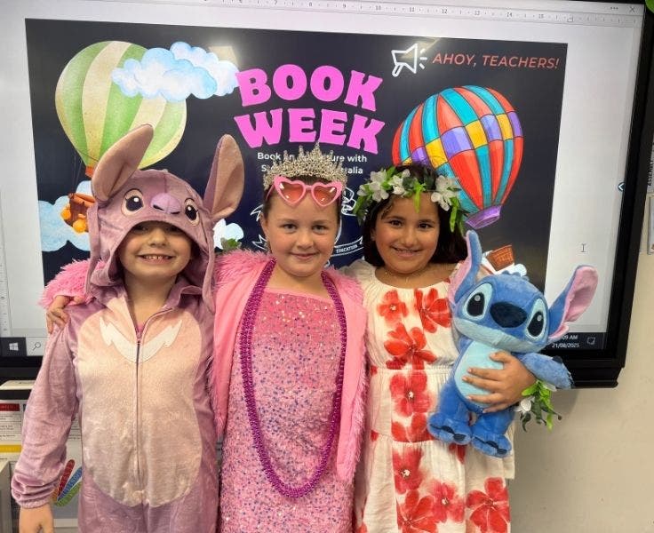 Three students dressed in costumes to celebrate Book Week