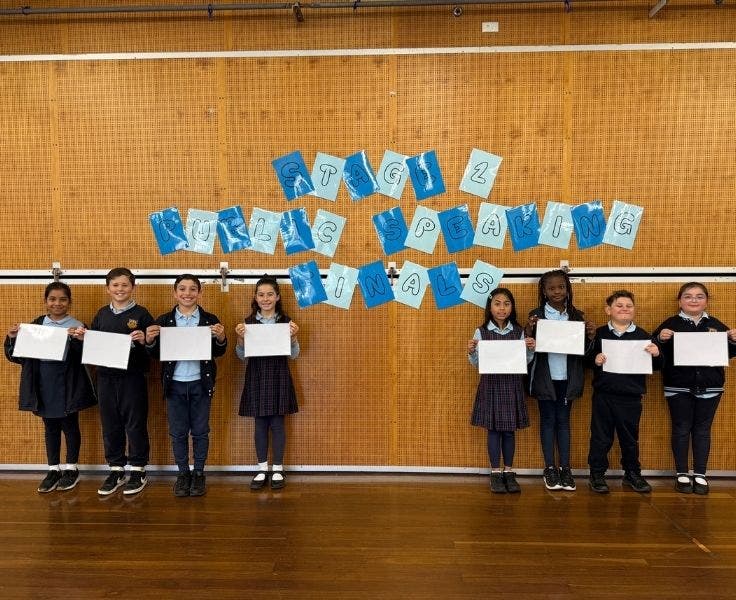Eight students holding up signs